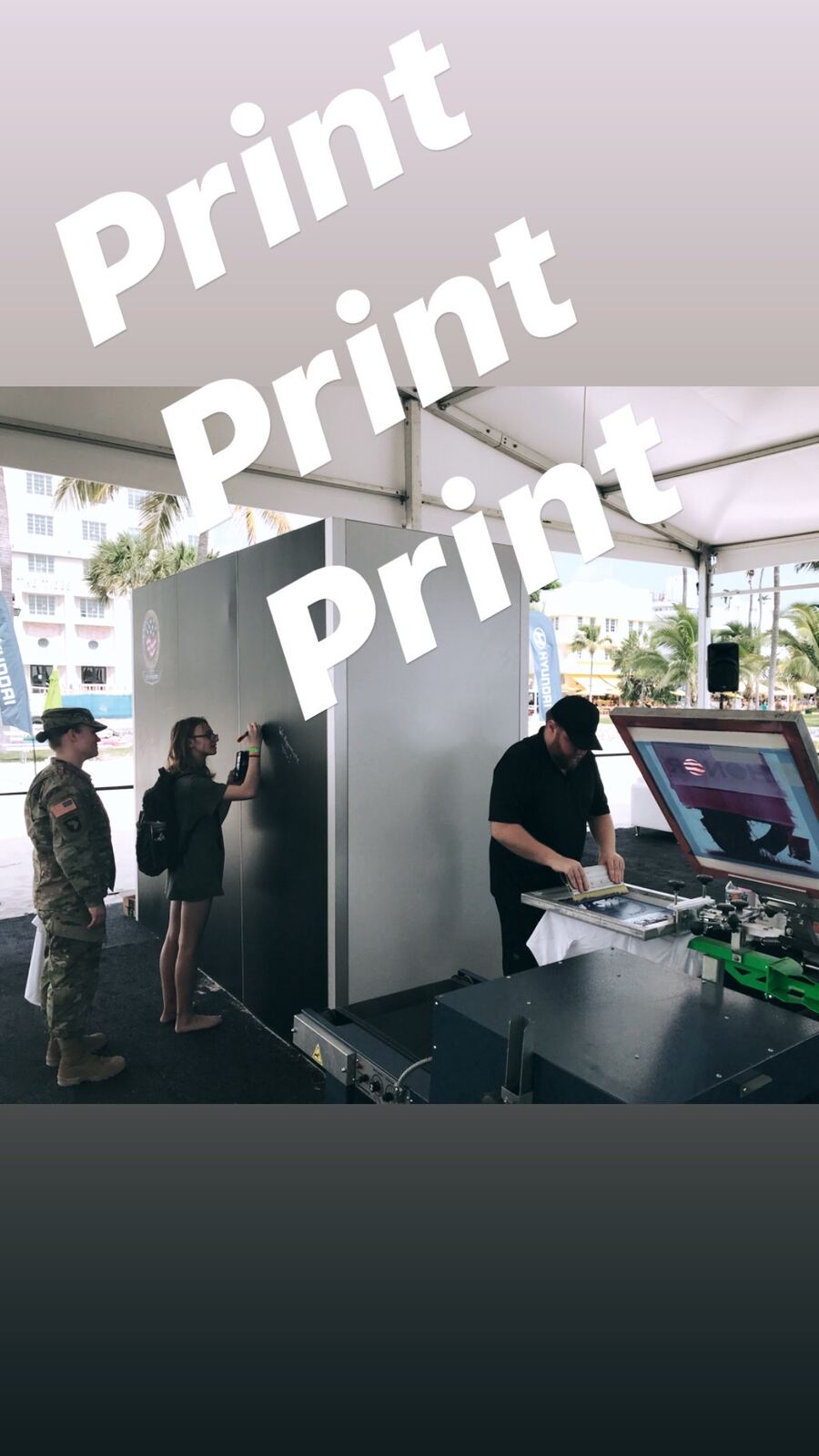 Outdoor event activation under tent with a large digital print demonstration showing attendees live printing capabilities