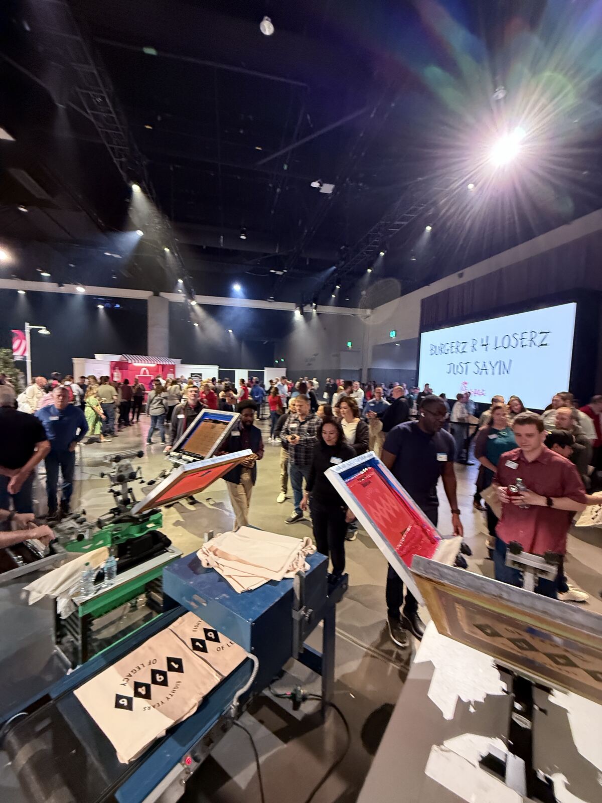 Night event venue with crowds and printed promotional materials and signage visible